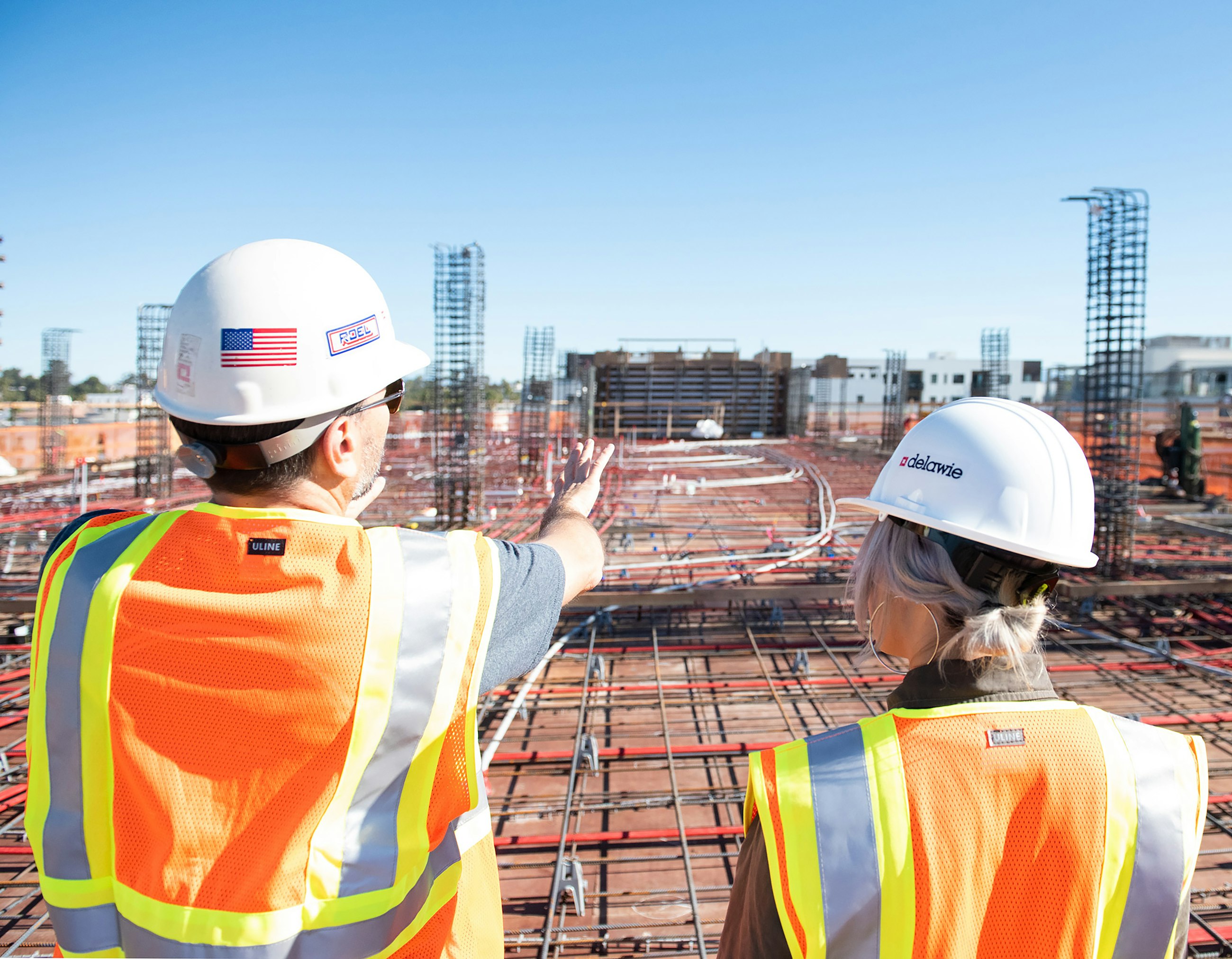 Engineers in hard hats and hi-vis vests reviewing a construction site
